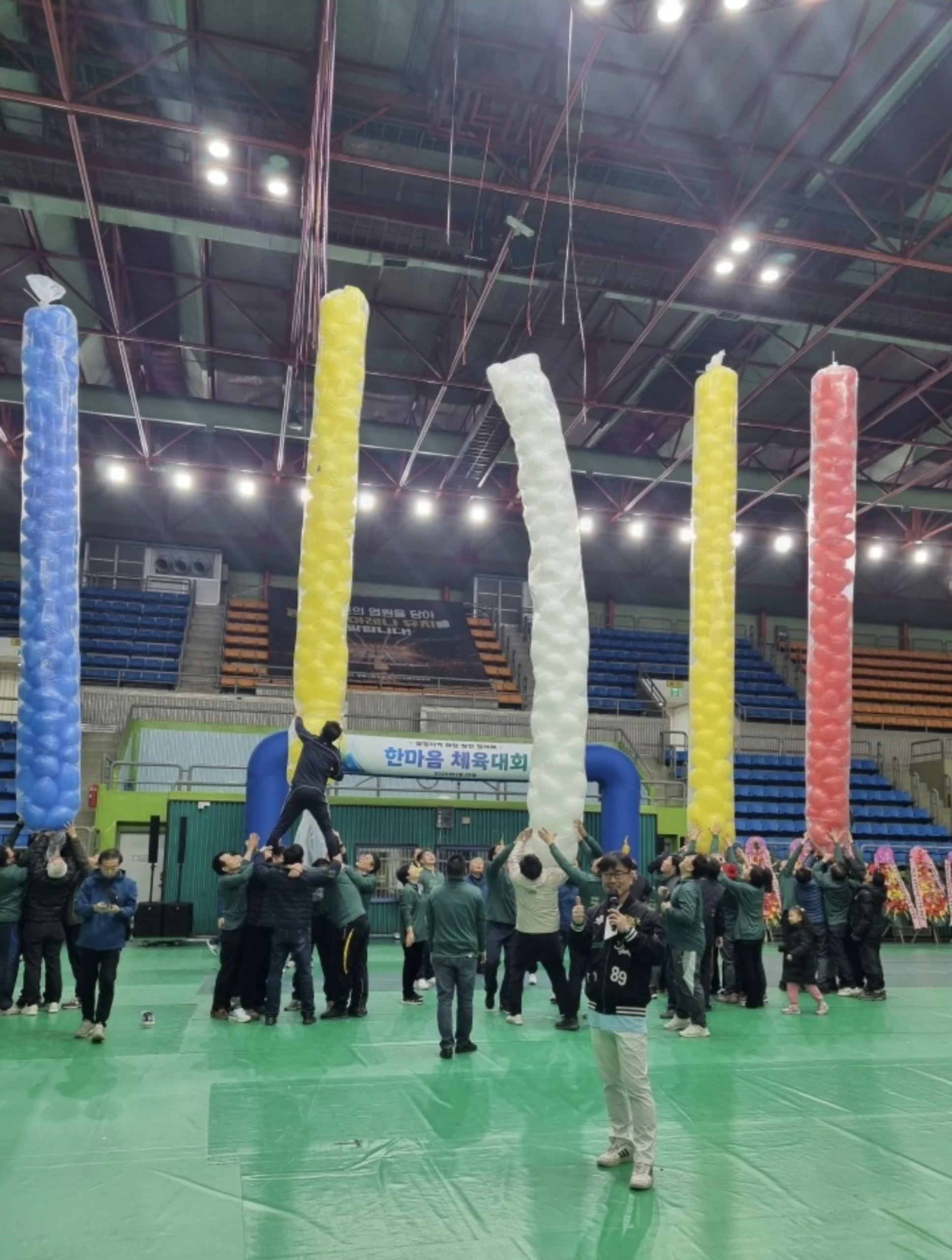 경기장에 색색의 풍선 기둥이 세워지고 멀리 체육대회 참가자들이 모인 모습