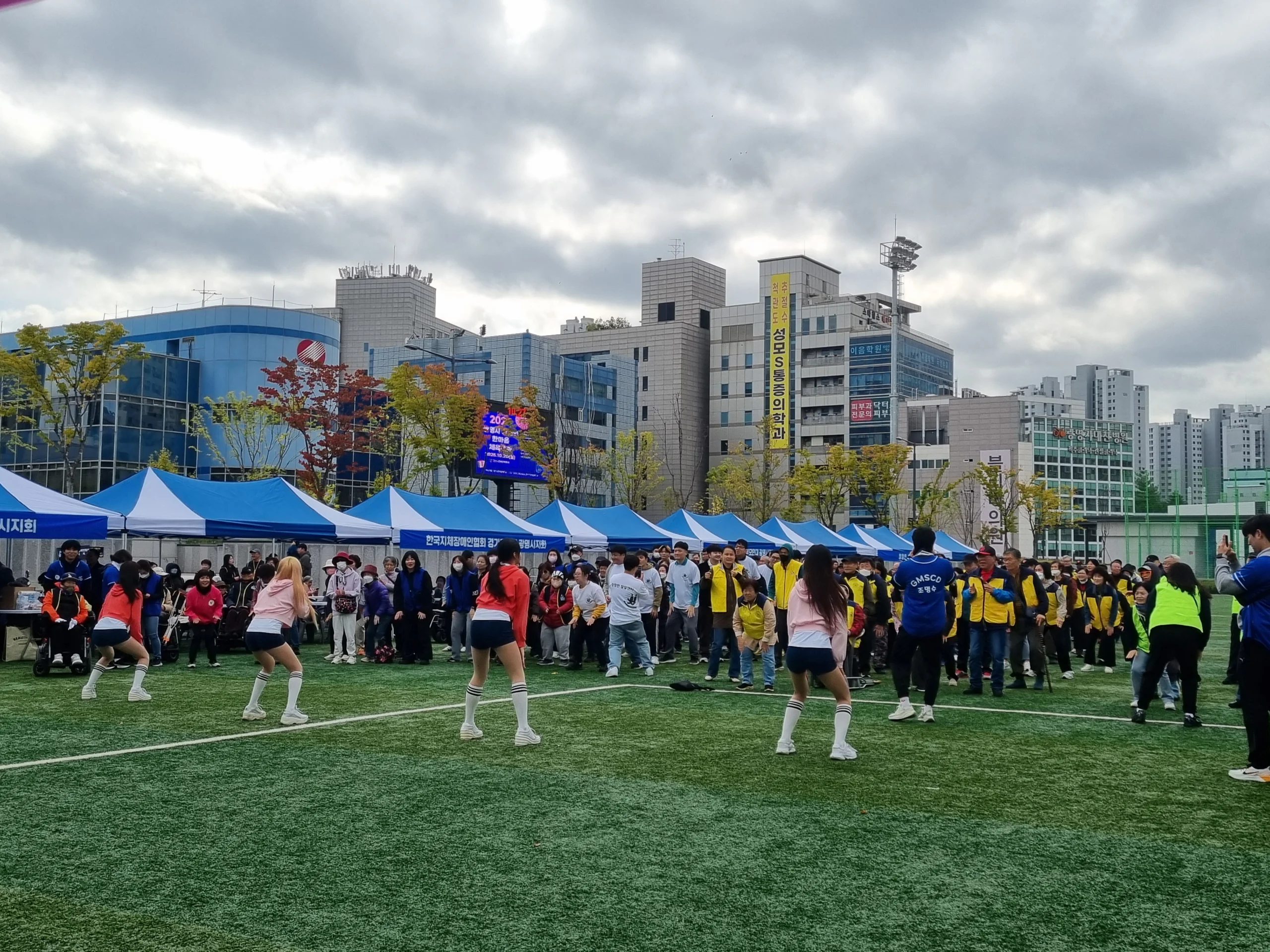 텐트가 설치된 도심 야외 운동장에서 멀리 보이는 참가자들